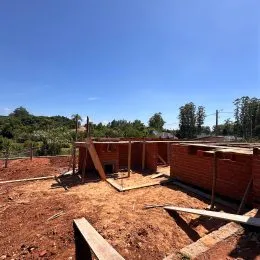 Foto de uma área externa com terra e estrutura de madeira em um terreno.