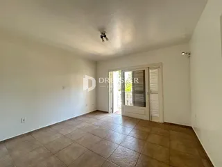 Interior de uma sala com piso de cerâmica e paredes brancas.