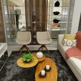 Sala de estar com sofá e estantes de vidro em um ambiente bem iluminado.