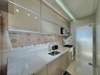 Imagem de uma cozinha moderna com armários brancos e revestimento de azulejos.