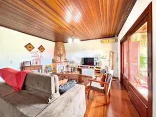Sala de estar com piso de madeira e lareira em ambiente residencial.