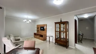 Sala de estar com sofá e móveis de madeira em um imóvel no Brasil.