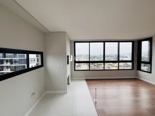 A sala de estar possui grandes janelas com vista para a paisagem urbana.