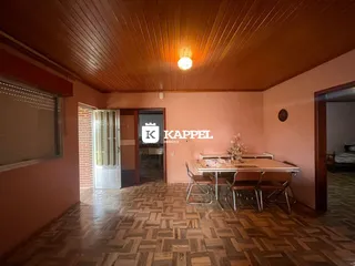 Sala de jantar com mesa e cadeiras em um ambiente com piso de madeira.