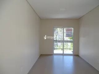 Interior de uma sala de estar com paredes brancas e piso claro.