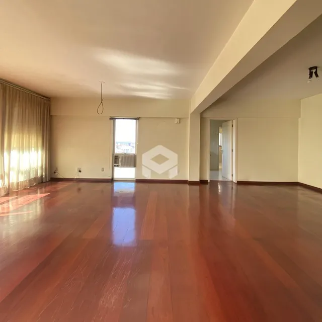 A sala apresenta um piso de madeira polida.
