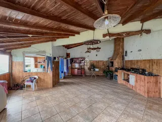 Ambiente interno de uma sala ampla com teto de madeira rústica.