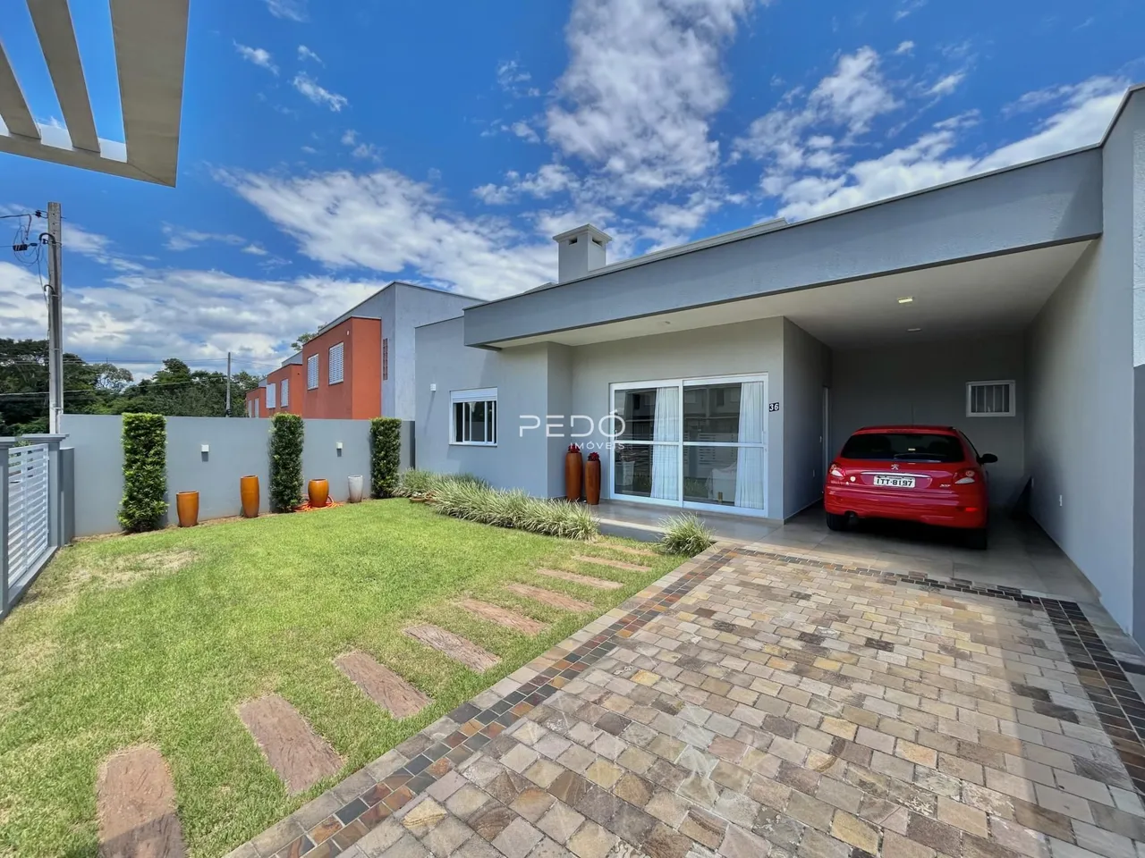 Vista externa de uma casa moderna com jardim e paisagismo em Lajeado.