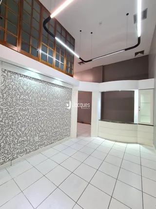 Interior de uma sala com piso de cerâmica clara e parede texturizada.