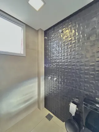 Parede com revestimento geométrico escuro em um ambiente interno.