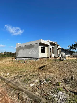 Fachada de uma casa em Lajeado, Brasil, com estrutura de concreto aparente e terreno seco.