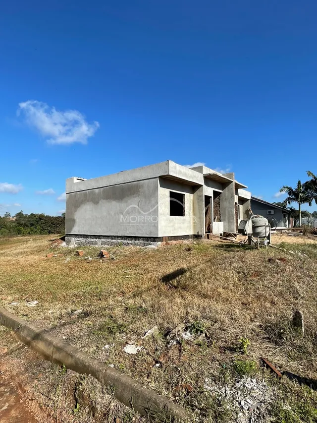 Fachada de uma casa em Lajeado, Brasil, com estrutura de concreto aparente e terreno seco.