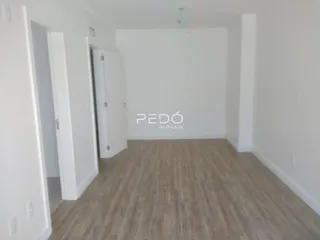 Hall de entrada com piso de madeira clara e paredes brancas.