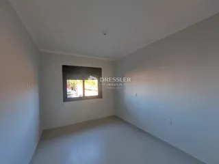 Vista interna de um cômodo com paredes brancas e piso claro.
