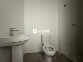 Banheiro com pia e vaso sanitário brancos.