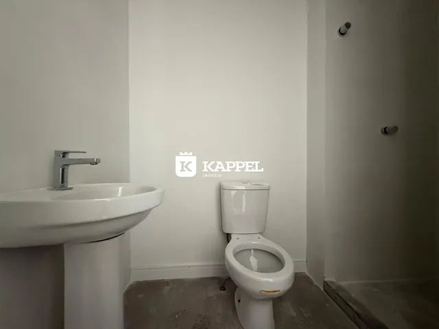 Banheiro com pia e vaso sanitário brancos.