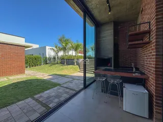 A sala de estar se abre para um pátio gramado com vista para o jardim.