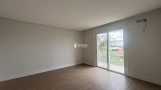 Ambiente interno com piso de madeira clara e grande janela.