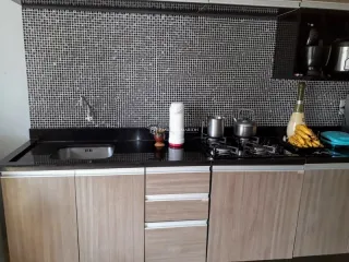 Cozinha com armários de madeira e backsplash de ladrilhos brancos.