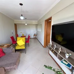 Sala de estar com televisão montada na parede.