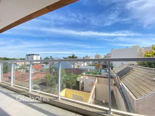 Vista da varanda com telhados e edifícios ao fundo