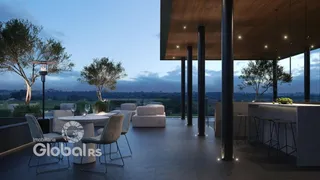 Vista de uma área de lazer externa com mesa e sofás em um imóvel.