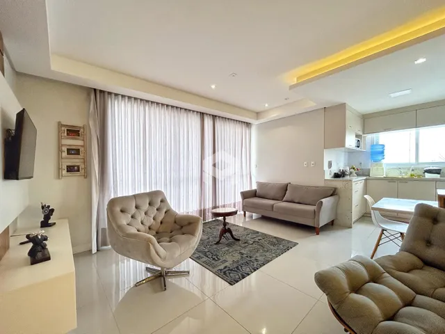 Sala de estar moderna com sofá e poltronas em um ambiente claro.