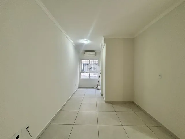 Foto do corredor interno de uma residência com piso de cerâmica.