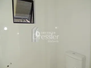 Parede interna branca com um vaso sanitário visível.
