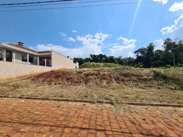 Foto da fachada de uma propriedade com grama seca no primeiro plano.