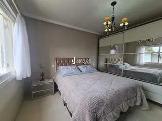Quarto com cama e espelho em um imóvel no Brasil.