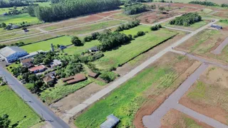 Vista aérea de uma propriedade rural com campos e estruturas dispersas.