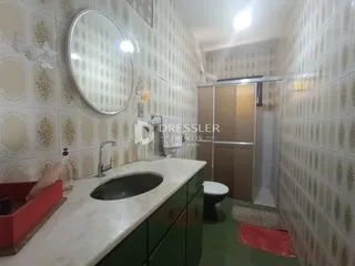Foto de um banheiro com revestimento de azulejos claros e bancada branca.
