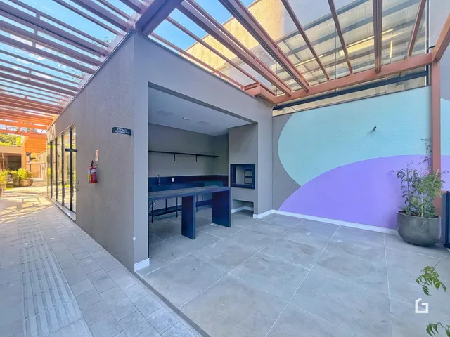 Área externa com teto de vidro e parede colorida de uma residência em Lajeado.
