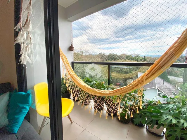 Vista da varanda de uma residência em Lajeado, Brasil, com decoração de plantas e cortinas.