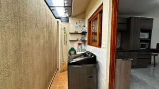 Vista de um corredor interno com parede texturizada e janela no ambiente.