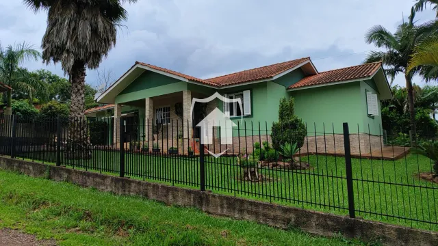 Fachada de uma residência em Lajeado, Brasil, com cerca e jardim frontal.
