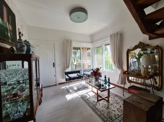 Sala de estar com piso de madeira e grandes janelas.