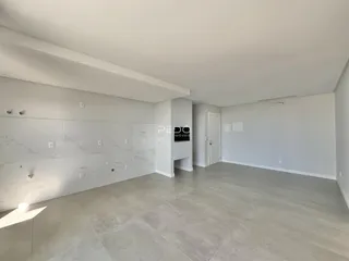 Ambiente interno amplo com piso de cerâmica e paredes brancas.