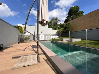 Foto da área externa com piscina e deck de madeira em Lajeado.