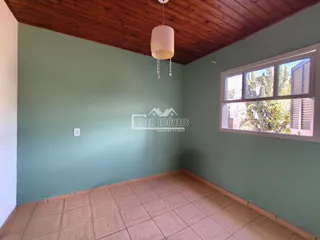 Foto de um cômodo interno com paredes verdes e piso de cerâmica.