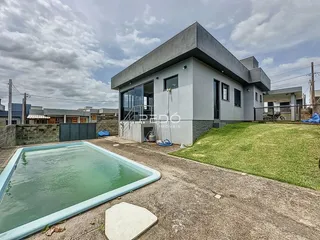 Vista externa de uma casa moderna com piscina e jardim em Lajeado, Brasil.