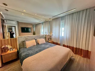 Quarto com cama grande e cortinas claras em um ambiente bem iluminado.