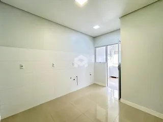 Corredor interno com paredes brancas e piso claro.