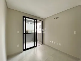 Interior de uma sala com porta de vidro que se abre para outra área.