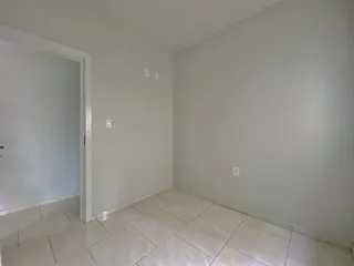 Hall de passagem com piso de cerâmica clara e paredes brancas.