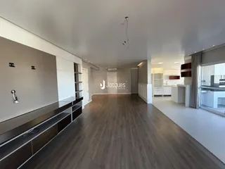 Sala de estar ampla com piso de madeira e armários embutidos.