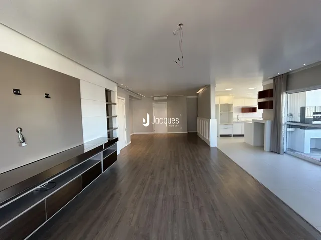 Sala de estar ampla com piso de madeira e armários embutidos.