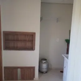Hall de entrada com prateleiras de madeira instaladas na parede.