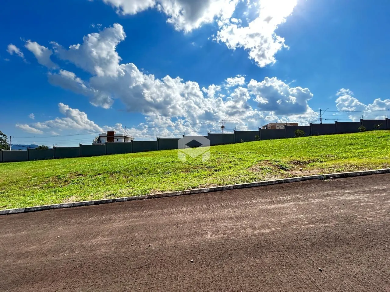 Vista externa de um terreno com gramado e cerca.